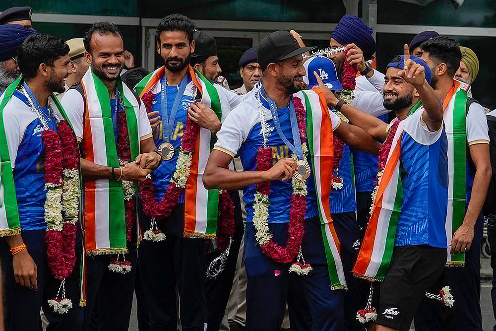 | Photo: PTI/Manvender Vashist Lav : Bronze medalist Indian Hockey players at the Indira Gandhi International Airport